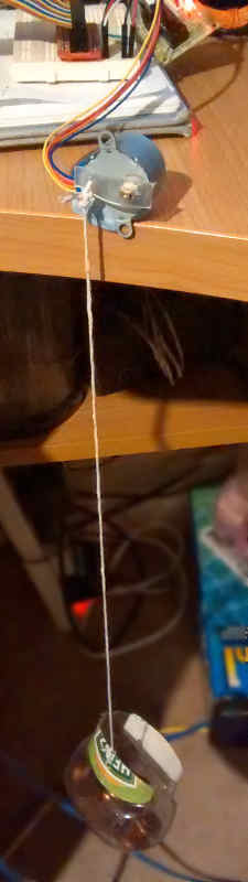 Stepper motor with plastic arm with hanging basket containing 1 pence coins