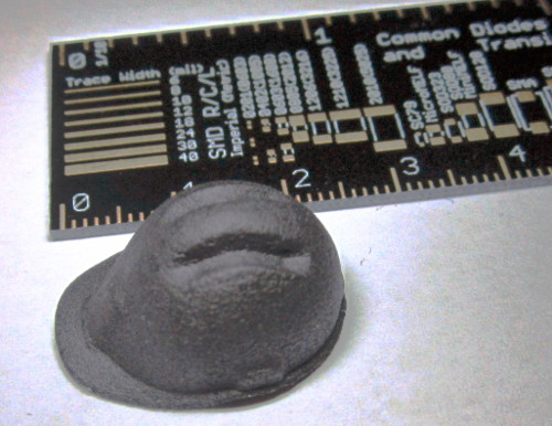 Photo of a tiny 3d printed hard hat next to a ruler